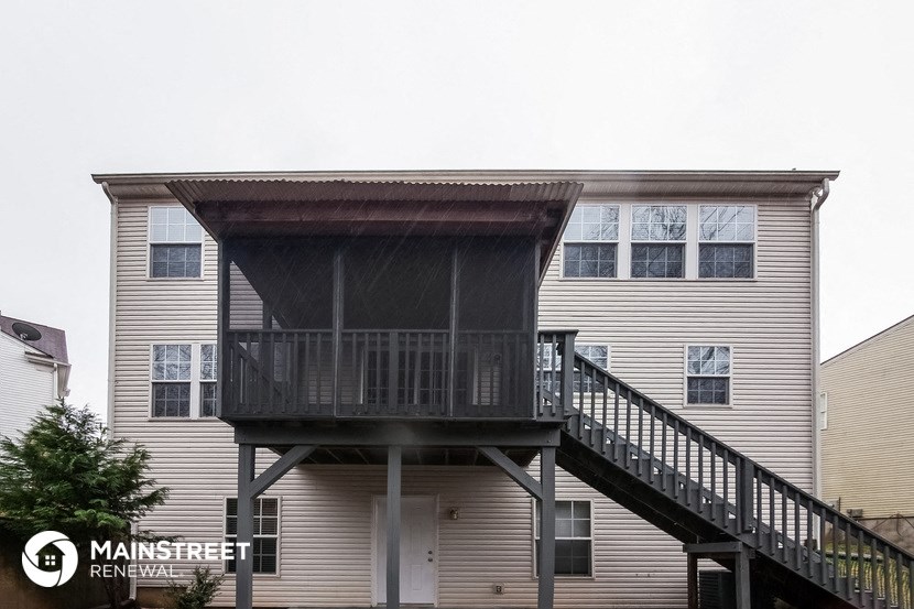 the back of a house with a deck and a balcony