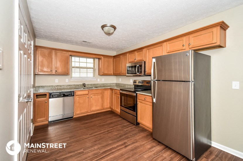 a kitchen with wooden cabinets and stainless steel appliances