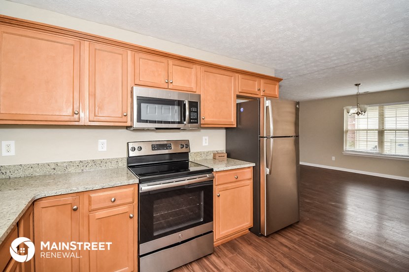 the kitchen has stainless steel appliances and wooden cabinets