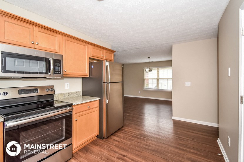 an empty kitchen with wooden cabinets and stainless steel appliances