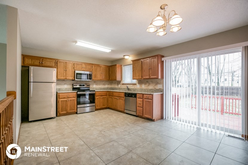 a kitchen with wooden cabinets and stainless steel appliances and a sliding glass door