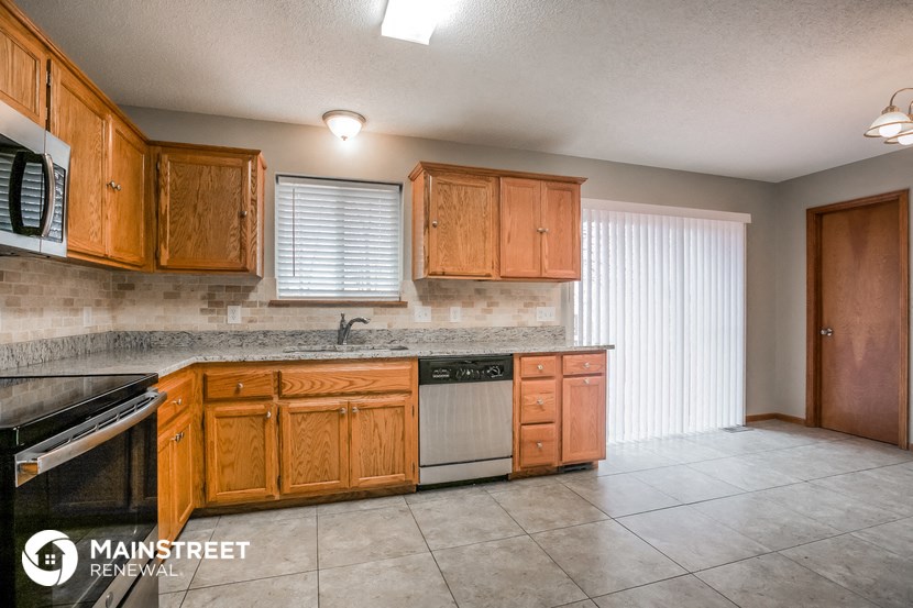 a kitchen with wooden cabinets and stainless steel appliances