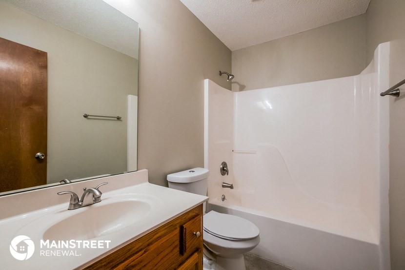a bathroom with a sink toilet and shower and a mirror