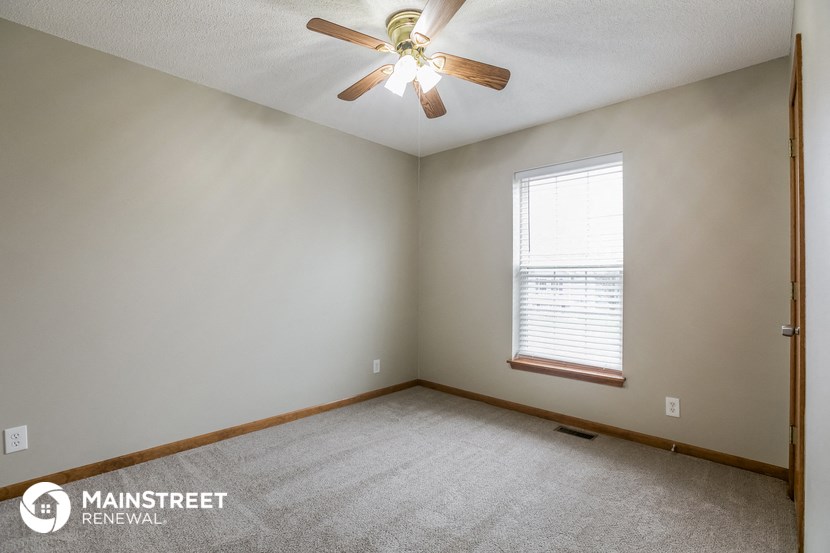 the living room of an empty house with a ceiling fan