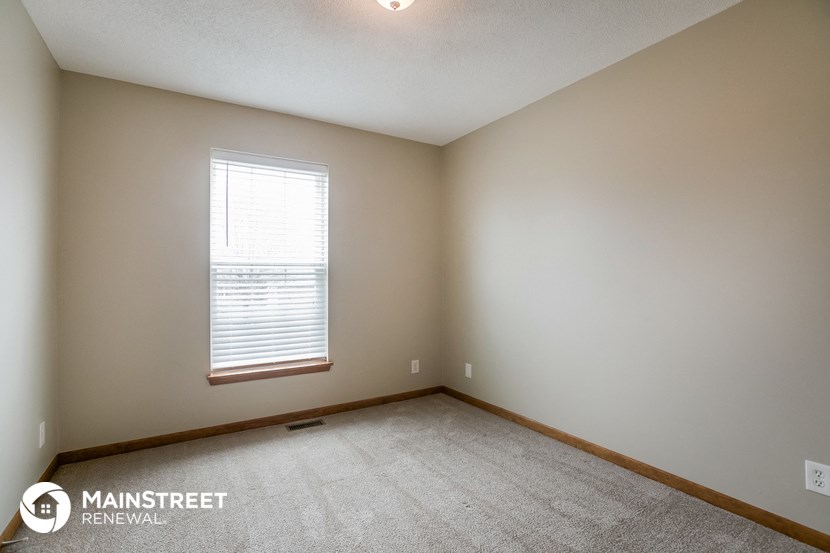 the upstairs bedroom with carpeting and a window