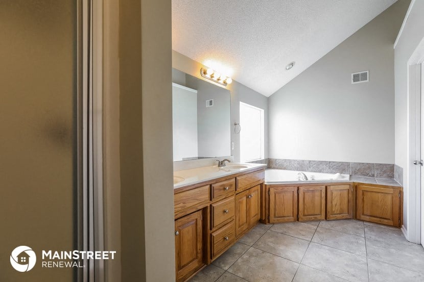 a bathroom with two sinks and a tub and a mirror
