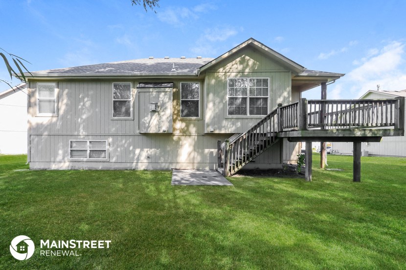 the front of a house with a deck and a staircase