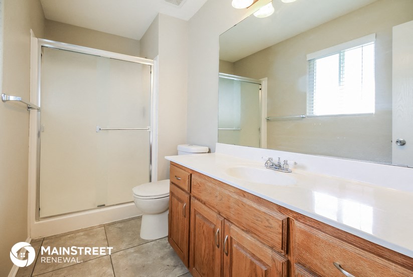 a bathroom with a large mirror and a sink and a toilet