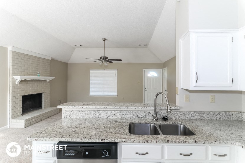 a kitchen with white cabinets and a granite counter top