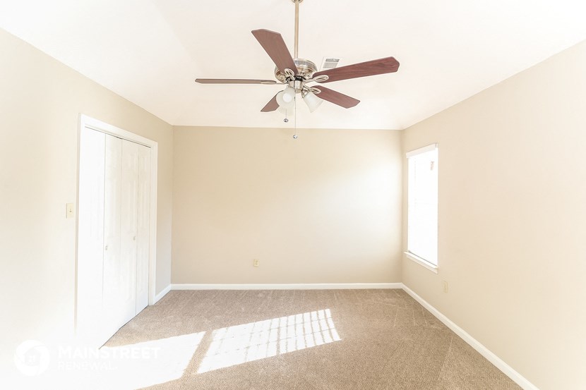 a empty room with a ceiling fan and a door