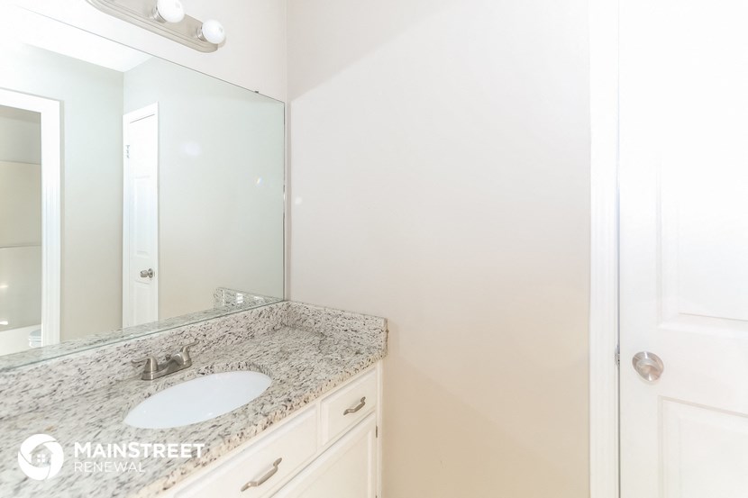 a bathroom with a sink and a mirror and a closet