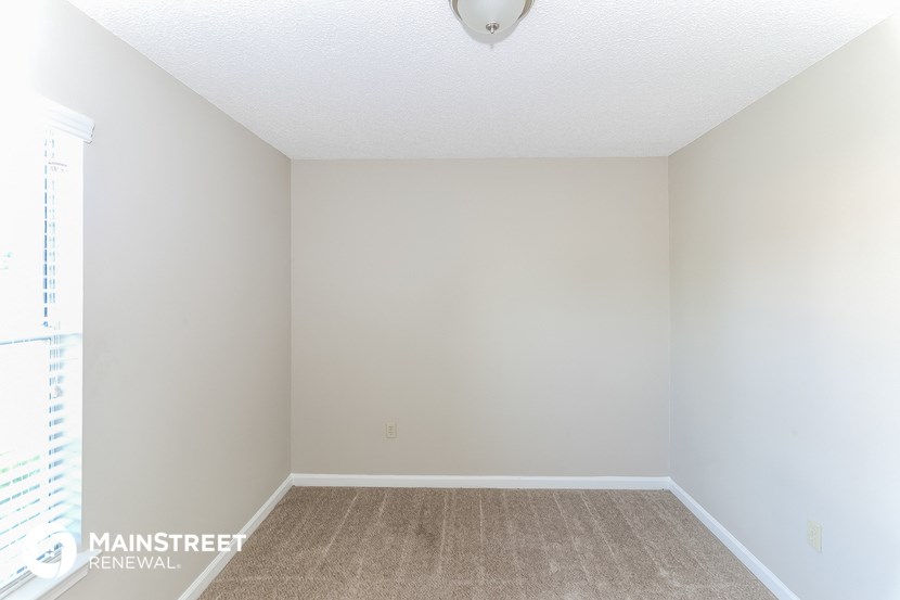 an empty room with white walls and a window