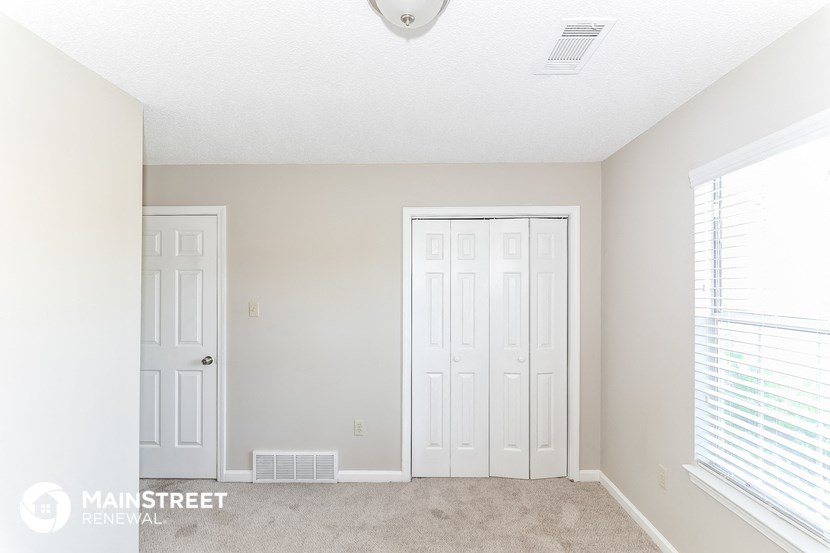a bedroom with two white doors and a carpeted floor