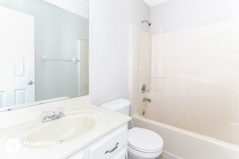 a white bathroom with a sink and a toilet and a tub