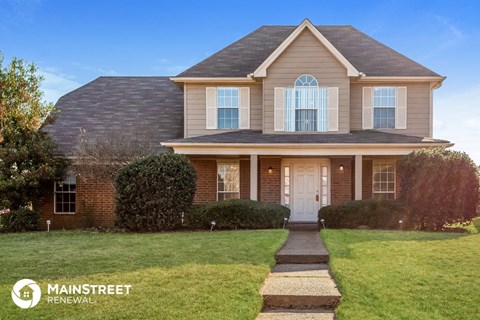 the front of a house with a lawn and a white door