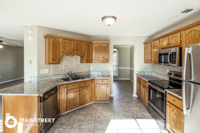 a kitchen with wooden cabinets and stainless steel appliances