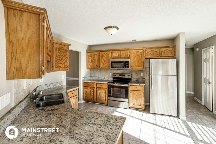 a kitchen with wooden cabinets and stainless steel appliances