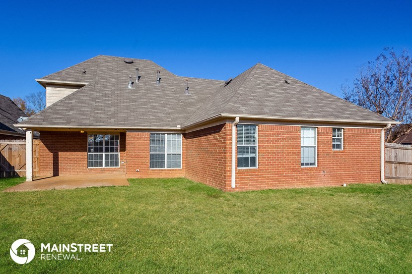 the front of a brick house with a gray roof