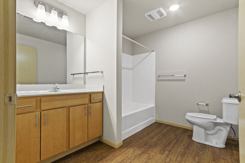a bathroom with a toilet sink and shower and a mirror