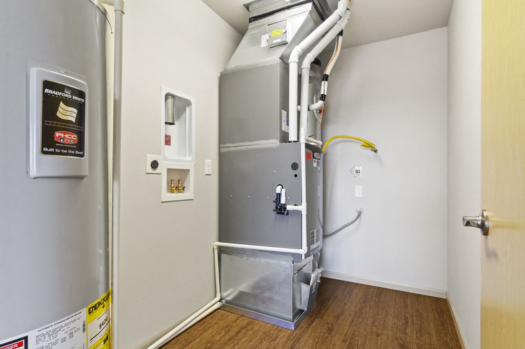 a stainless steel refrigerator in a room with wood flooring and a door