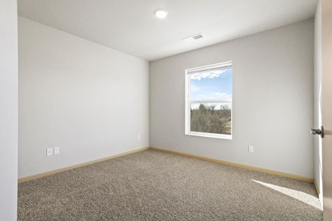an empty room with carpet and a window