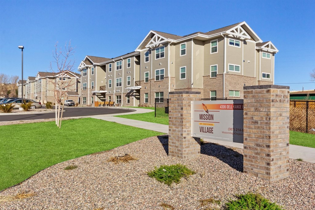an apartment building with a sign in front of it