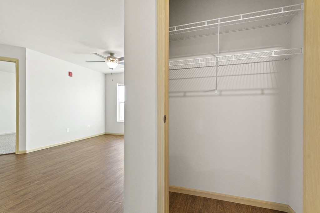 the living room of an empty apartment with a wood floor and white walls