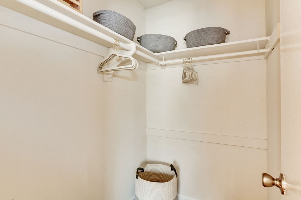 a small bathroom with a basket and a shelf with baskets