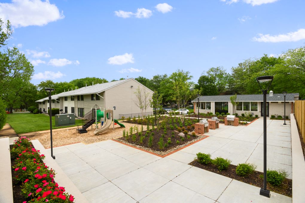 a courtyard with a playground and a house with a yard