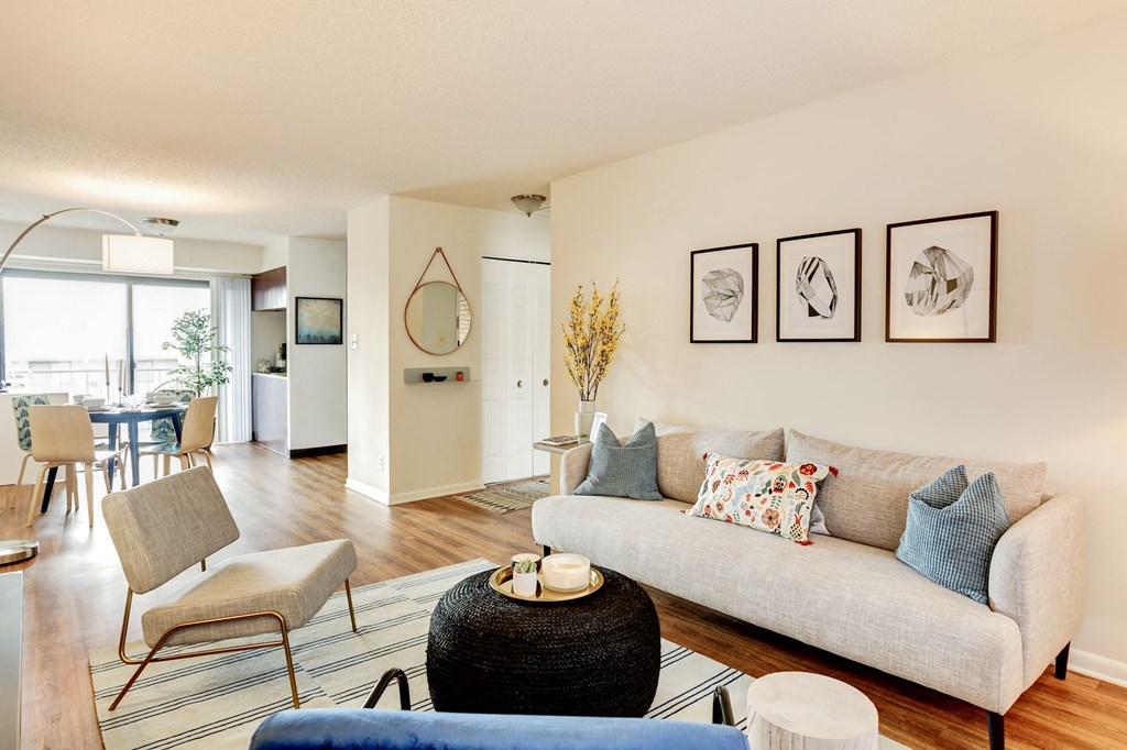 a living room with a couch and chairs and a dining room