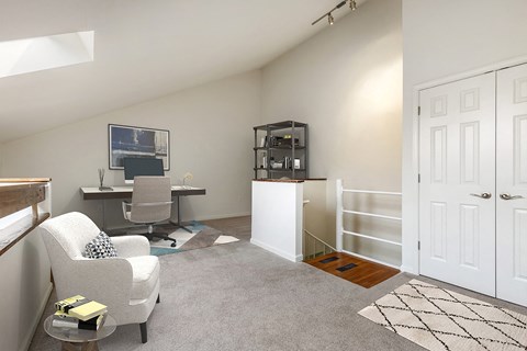 A living room with a grey carpet and a white chair.