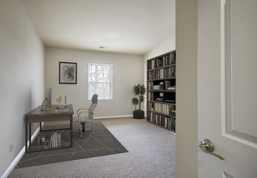 a home office with a desk and a bookshelf