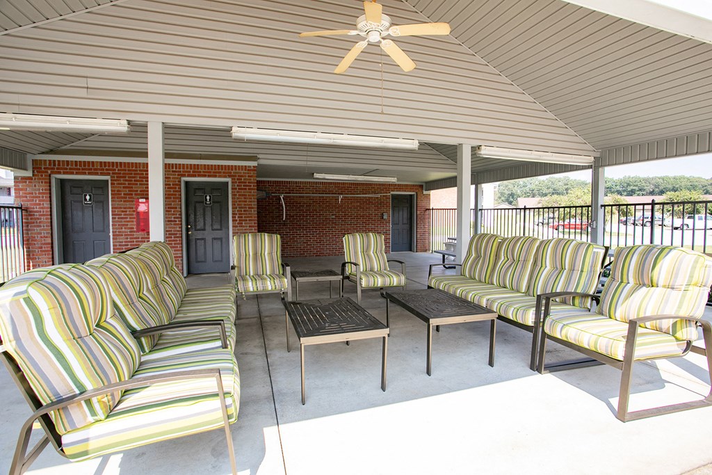a patio with couches and chairs and a ceiling fan
