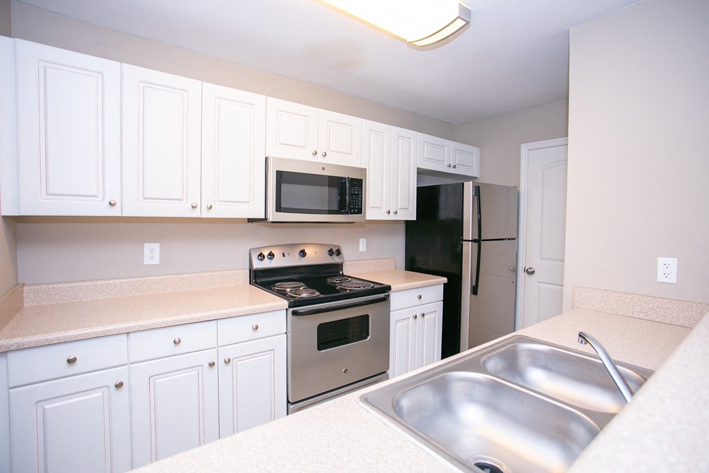 a kitchen with stainless steel appliances and white cabinets