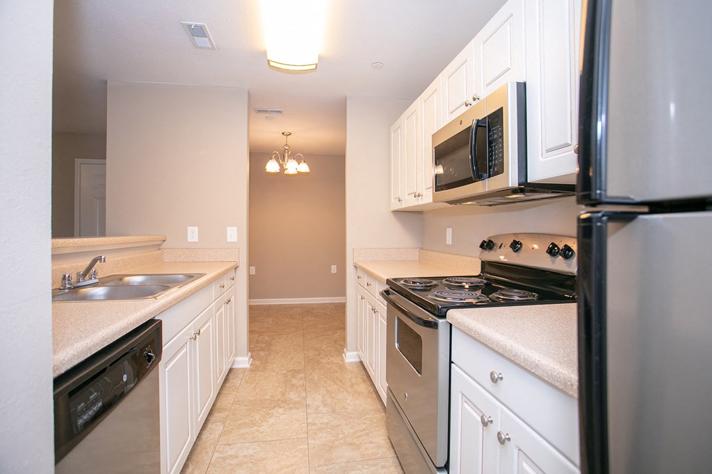 a kitchen with stainless steel appliances and white cabinets
