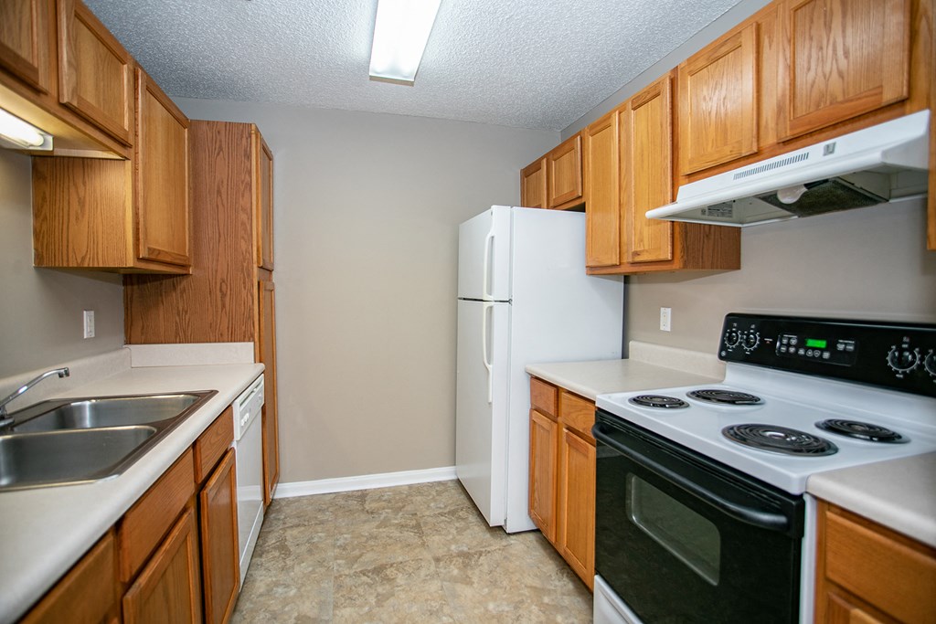 an empty kitchen with a stove refrigerator and sink