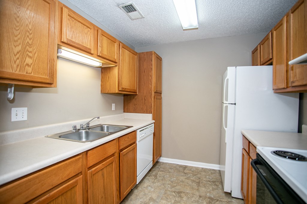 a kitchen with white appliances and wooden cabinets