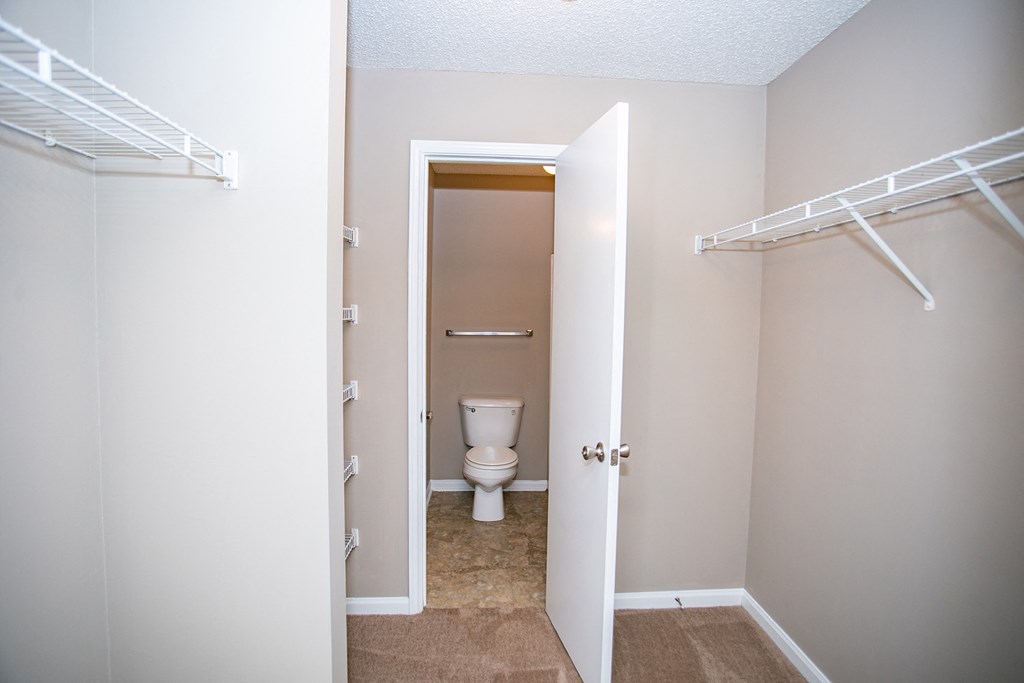 an empty closet with a toilet in a bathroom