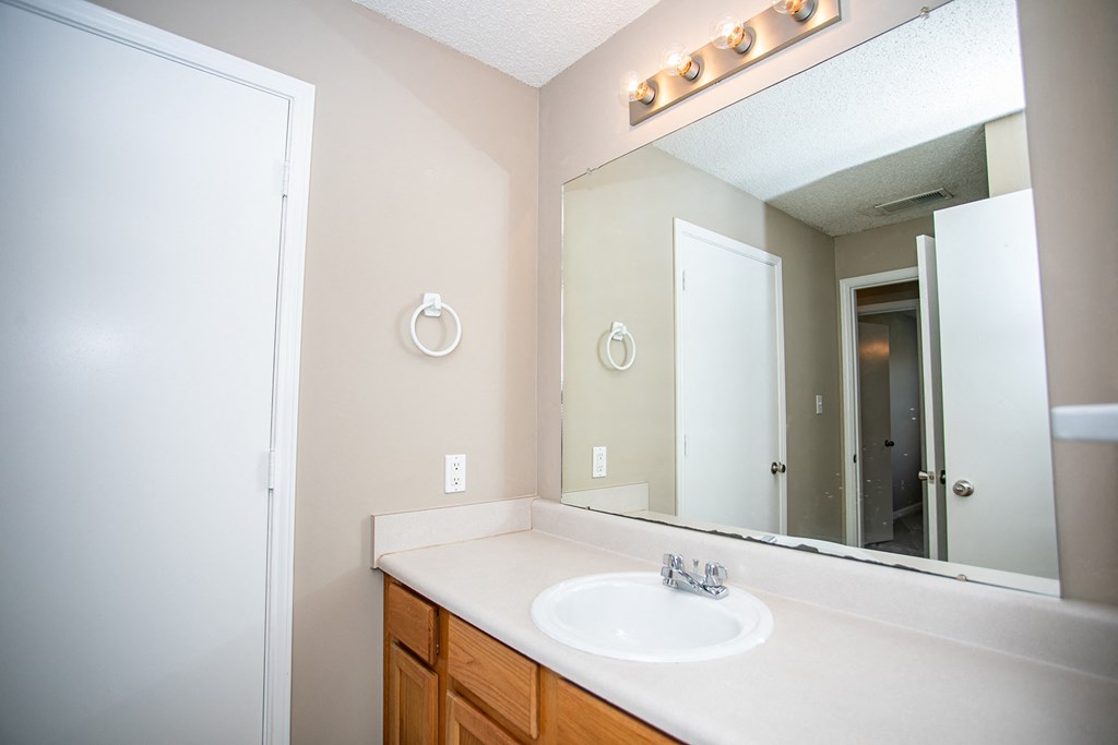 an empty bathroom with a sink and a mirror