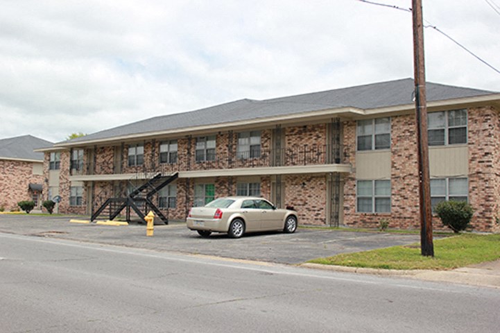 a car parked in front of a brick apartment building