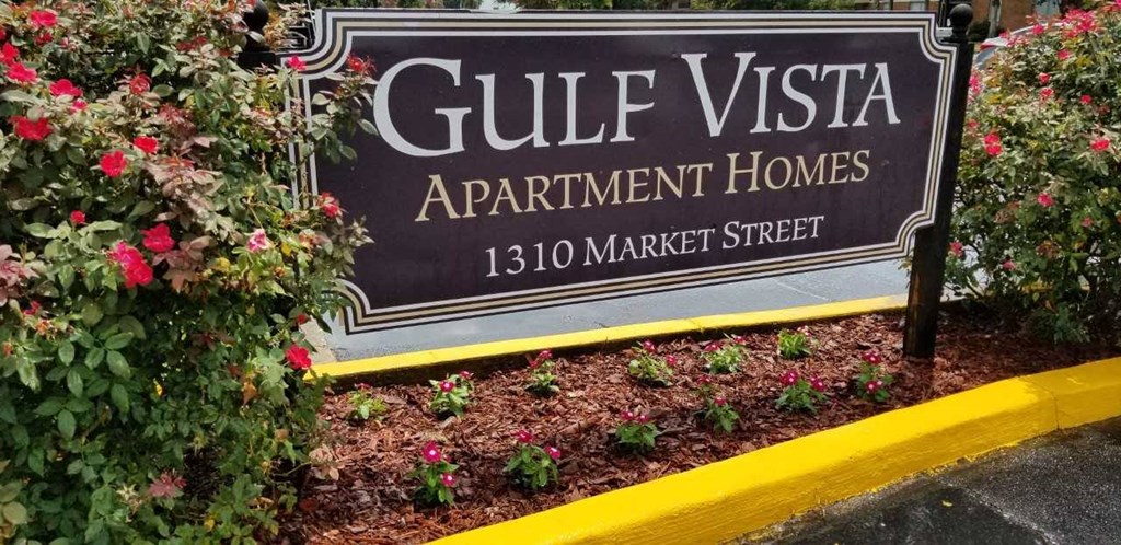 a sign forguilt vista apartment homes in front of some flowers