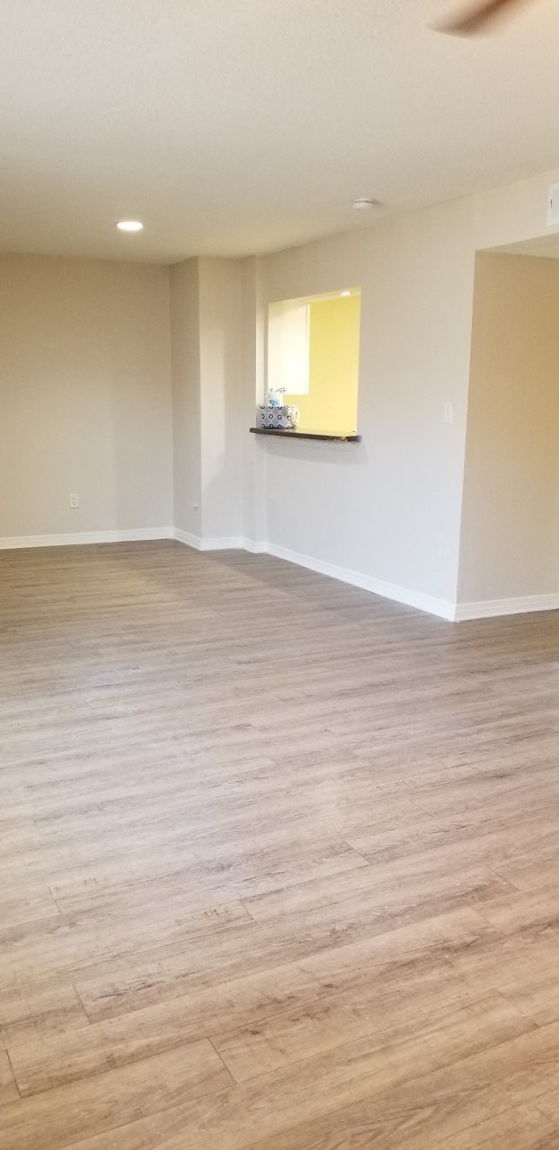 an empty living room with white walls and wood floors
