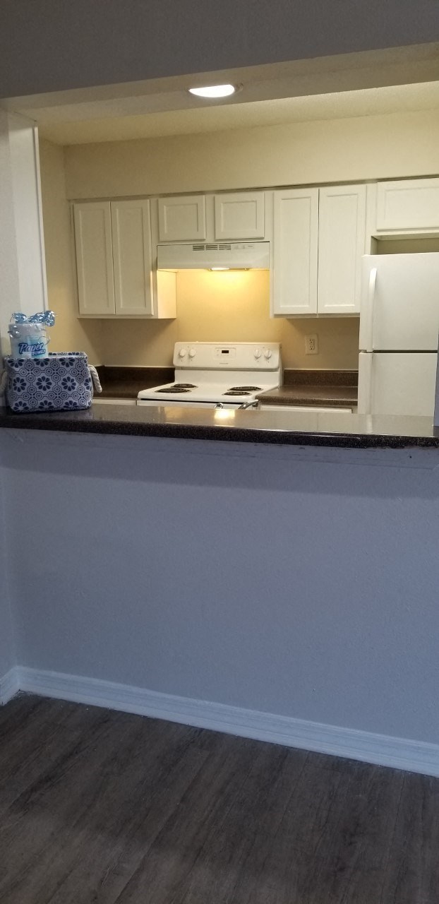 a kitchen with white cabinets and a counter top