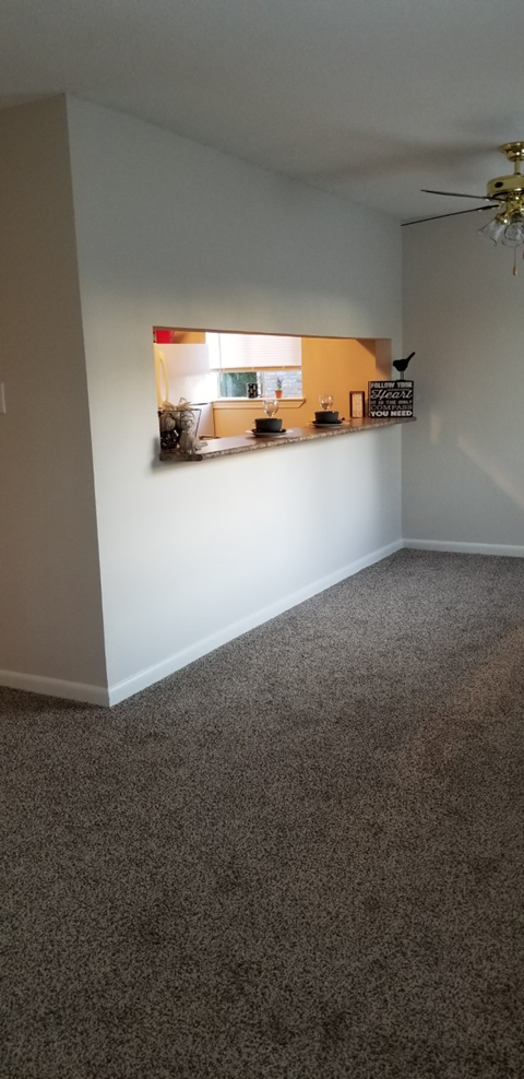 a living room with a white wall and a shelf on the wall