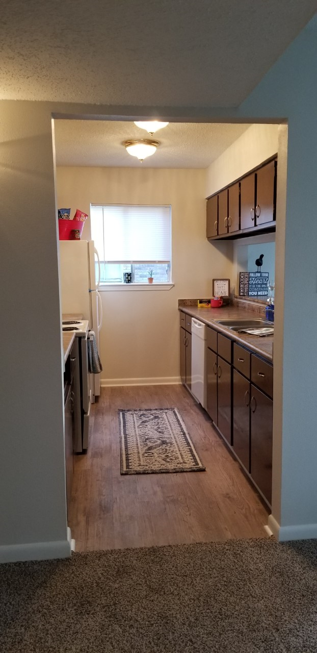an empty kitchen with a sink and a refrigerator