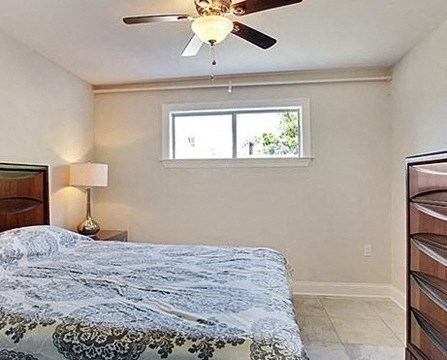 the bedroom has a large bed and a ceiling fan