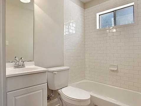 a white bathroom with a toilet and a tub and a sink