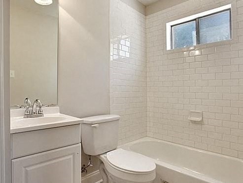 a white bathroom with a toilet and a sink