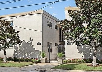 a building with a gate and trees in front of it