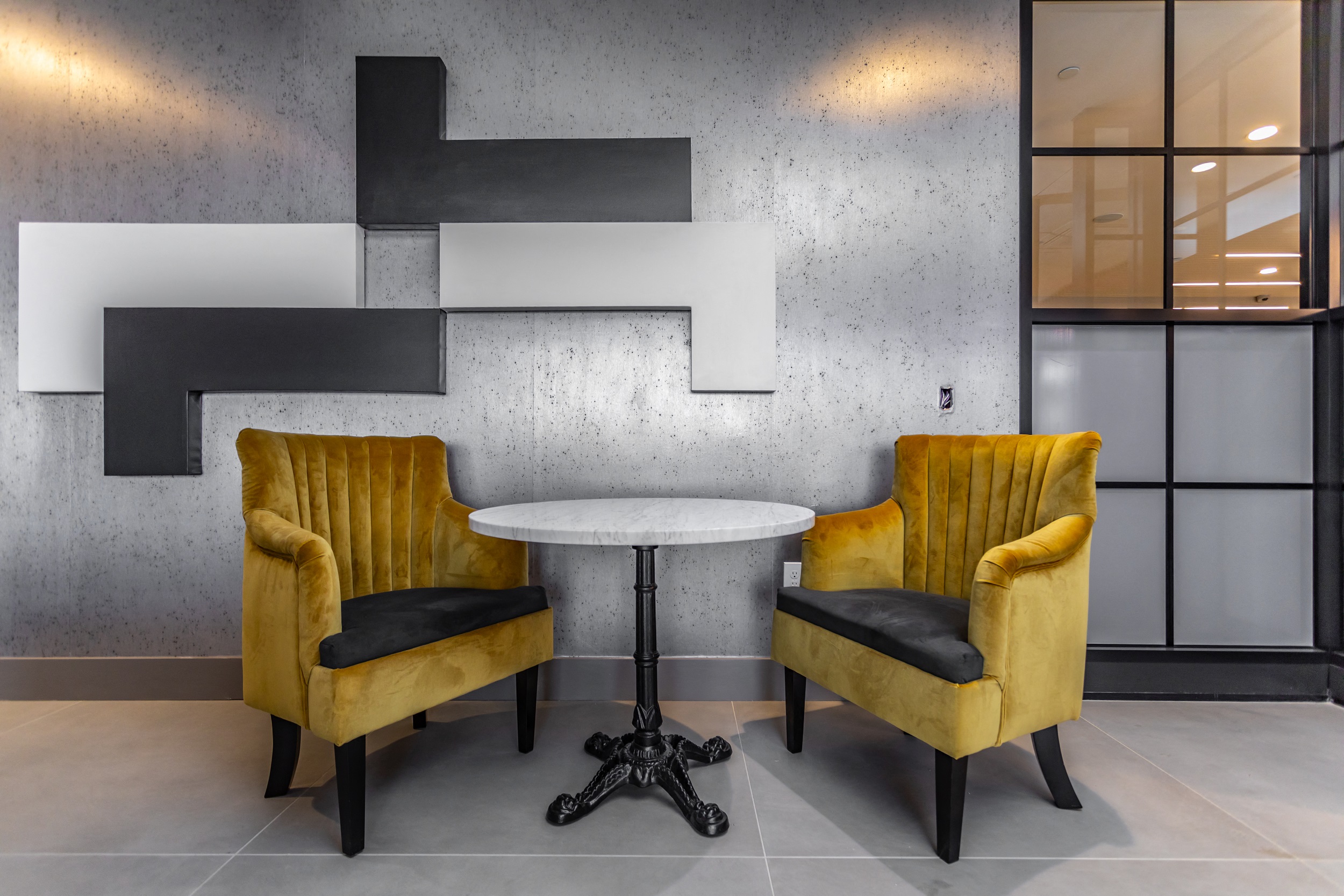 Vintage yellow chairs and table in common area at The Kelly Apartments in Bala Cynwyd